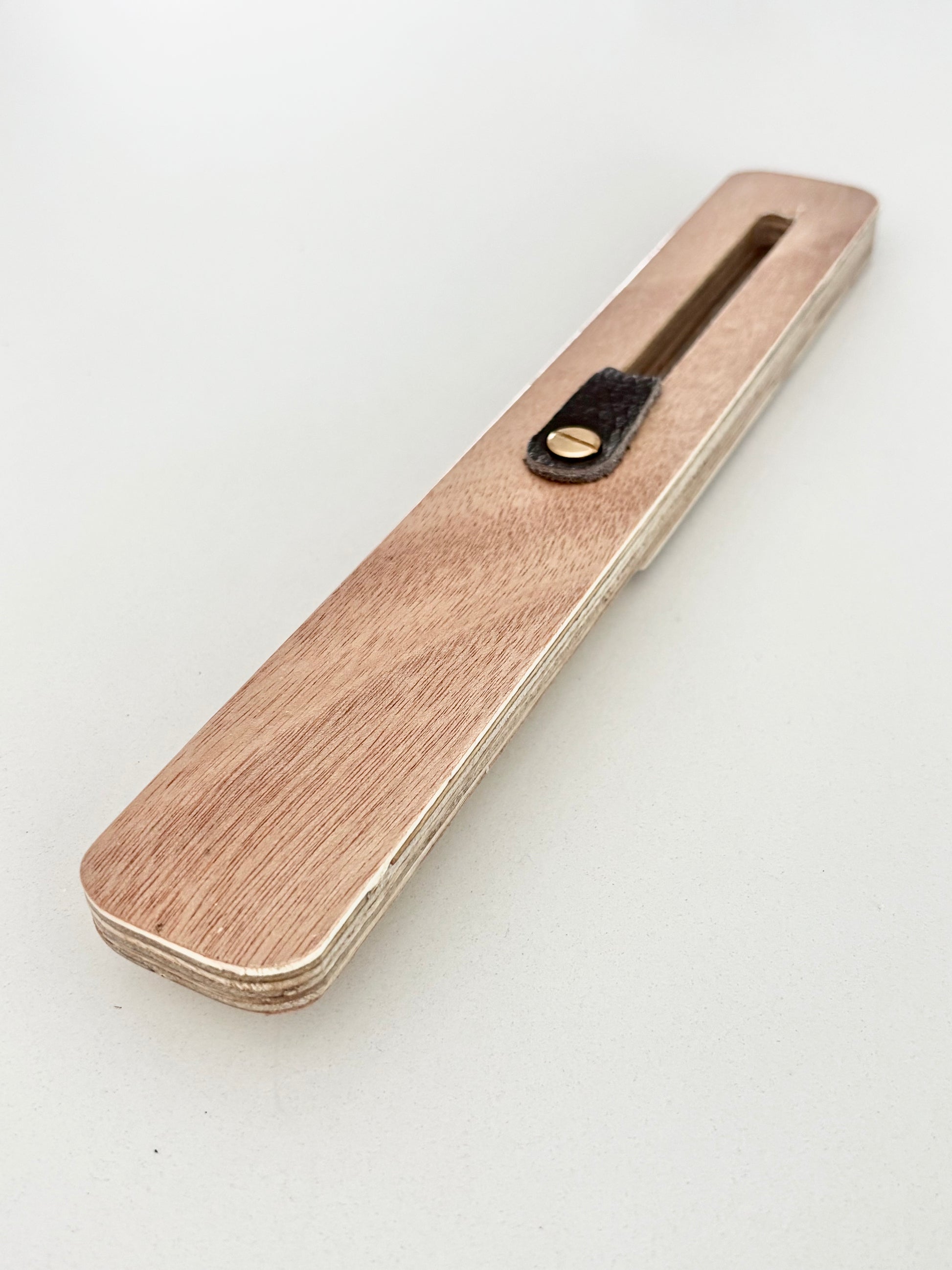 The FinEase wooden surfboard fin puller tool with leather protection strip